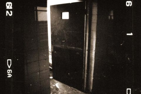 Porte entrouverte sur un couloir sombre, bordures de pellicule, salle L'institut du Dr Freeman, The four gates à Soissons