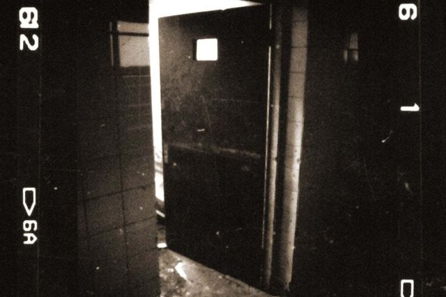 Porte entrouverte sur un couloir sombre, bordures de pellicule, salle L'institut du Dr Freeman, The four gates à Soissons