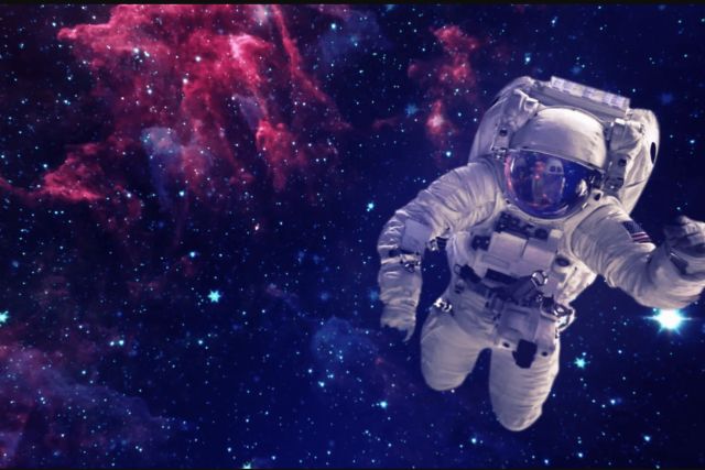 Astronaute flottant dans l'espace parmi des nébuleuses roses et bleues, salle Ultimatum à Amnéville