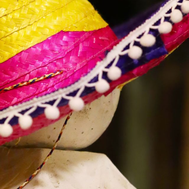 Sombrero jaune et rose à pompons sur un mannequin, salle Fiesta de los muertos chez Escape Time à Vezin-le-Coquet