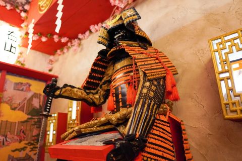 Armure de samouraï rouge et or assise devant un clavier, décor japonais, salle Le masque du samouraï, Timing Room