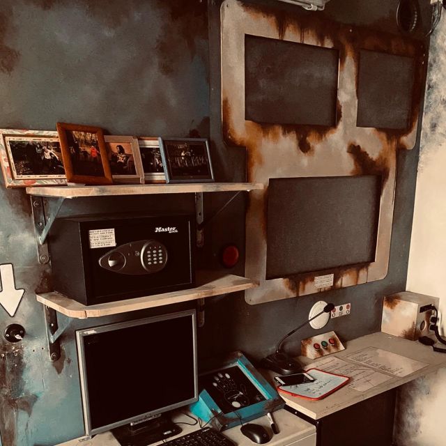 Coffre-fort à code et cadres photo sur un mur rouillé, salle Panic Room à Bruxelles