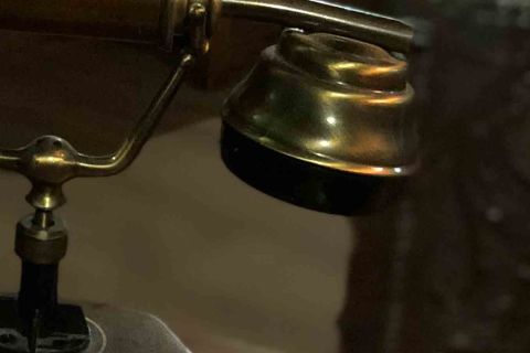Téléphone ancien à cadran sur un bureau dans la pénombre, salle Le mystère chez Octopus Mystery à Saint-Amand-Montrond