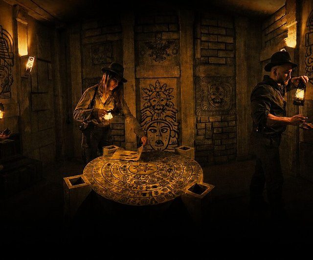 Explorateurs en tenue d'aventuriers autour d'un disque calendaire dans un temple maya