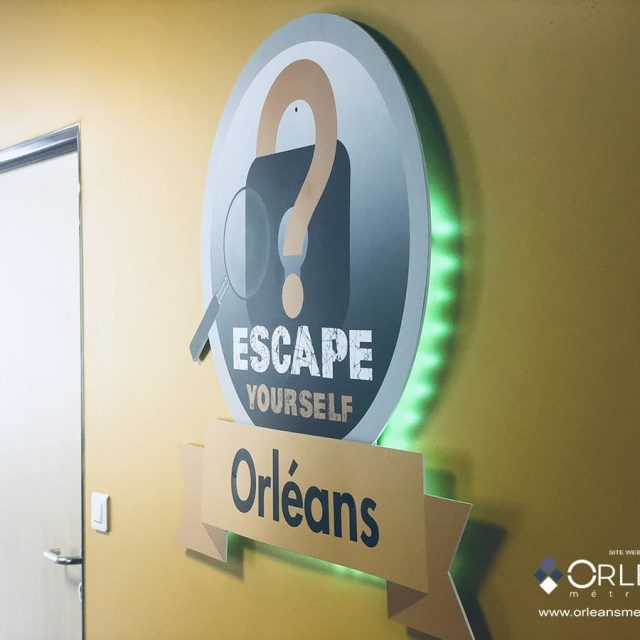 Logo d'Escape Yourself, escape game à Orléans, sur mur jaune