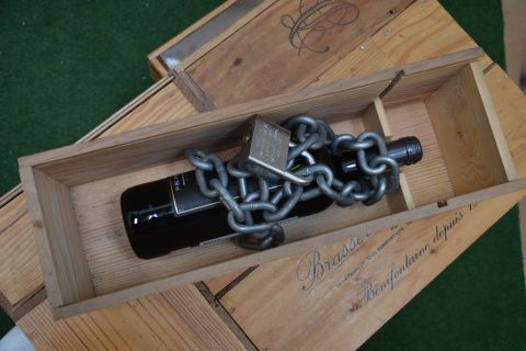 Bouteille de vin enchaînée et cadenassée dans une caisse de bois ancienne, salle Escape Wine chez Escape Game 62 à Bully-les-Mines