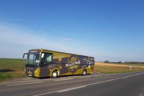 Autocar sur une route de campagne sous un ciel bleu, escape game mobile Magicbus à Potelle