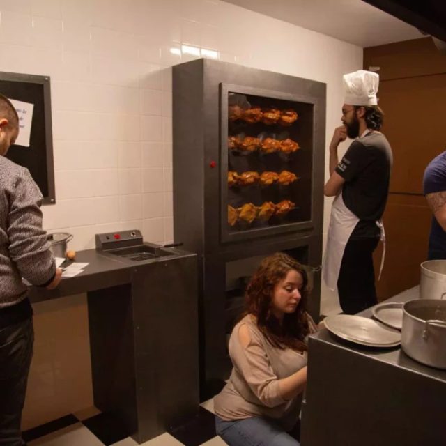 Joueurs affairés dans une cuisine avec rôtissoire, casseroles et cuisinier au fond, salle Panique en cuisine chez Gaillard Académie