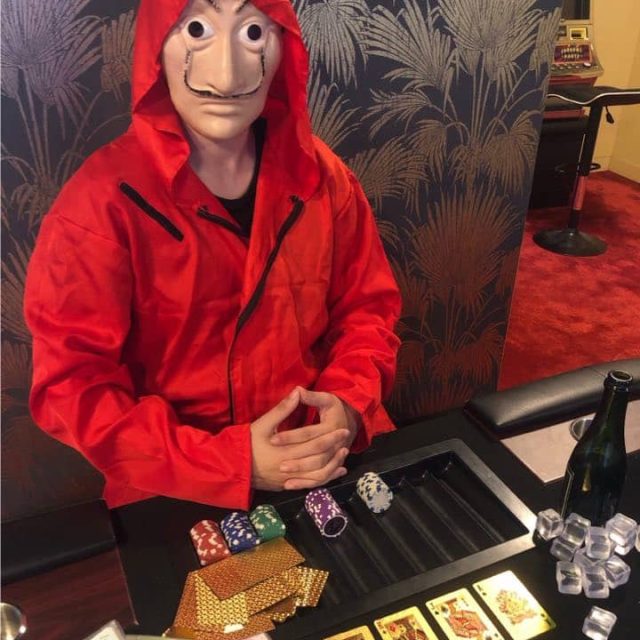 Joueur en veste rouge face à des jetons de poker dans Le Braquage chez Fun Room
