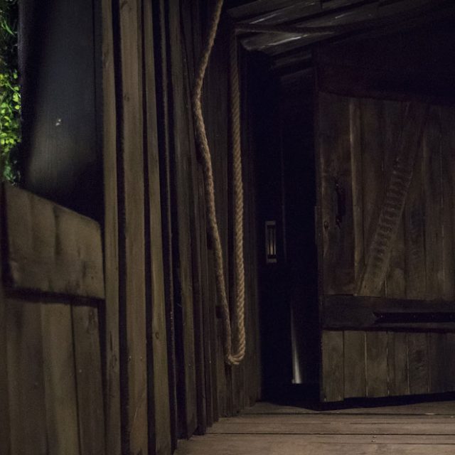 Couloir en bois sombre menant à une porte fermée, salle Projet Omega chez Escape Time à Saint-Herblain