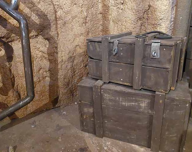 Caisses de bois empilées dans une galerie de roche près d'un tuyau, salle La ruée vers l'or chez Time Lapse