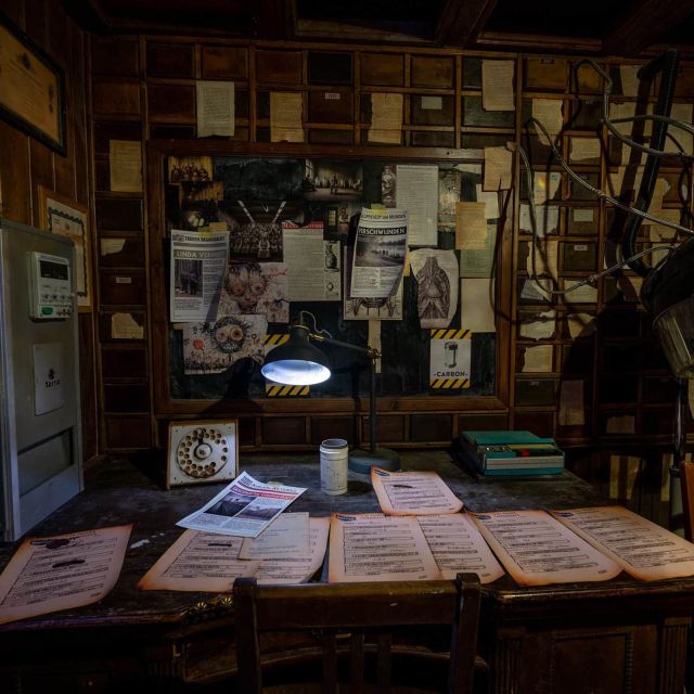 Bureau psychiatrique encombré de dossiers et documents dans l'asile de Mastermind à Bern