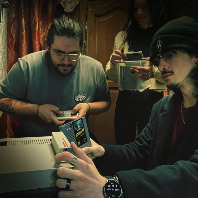 Deux joueurs examinant des cartouches de jeu devant une console rétro, salle Zoomanji chez Freeing à Saint-Maximin