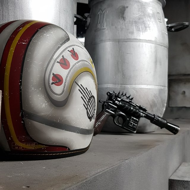 Casque futuriste, revolver et conteneurs métalliques dans l'univers sci-fi de Space War