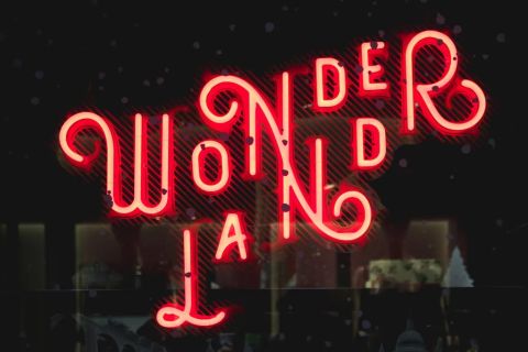 Enseigne néon rouge Wonderland aux lettres entrelacées sur fond sombre, Time Out Real Escape Game à Marseille