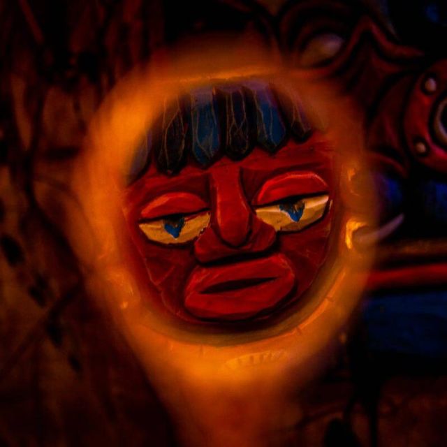 Masque rouge illuminé de néon orange dans la décoration de La cité interdite