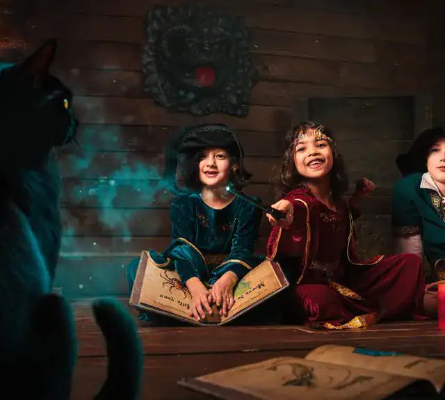 Trois enfants assis devant un grimoire, un chat noir au premier plan, Fairy Tale