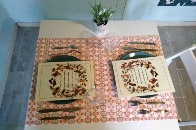 Table dressée avec deux sets à motifs fleuris et plante verte, salle Les poulettes chez Le Monde De L'Évasion