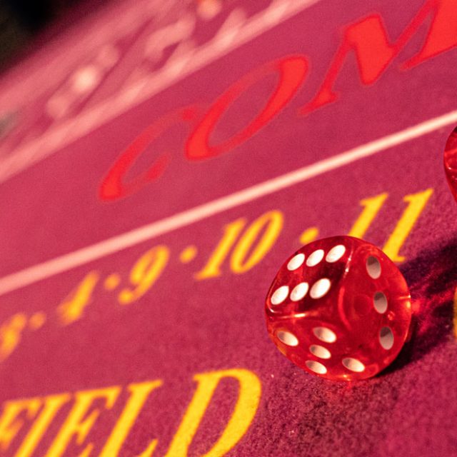 Table de craps à tapis rouge avec deux dés rouges, salle Alpha Casino chez Escape Time à Saint-Jean-de-la-Ruelle