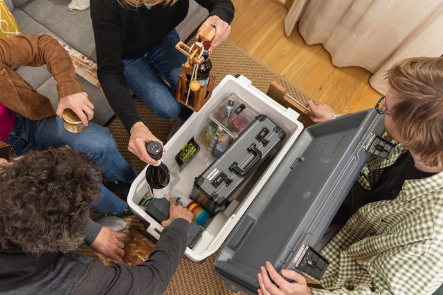 Groupe rassemblé autour d'une mallette contenant du matériel électronique et des accessoires