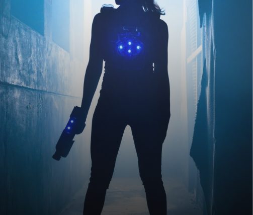 Silhouette de femme équipée d'un gilet luminescent bleu dans un couloir urbain brumeux