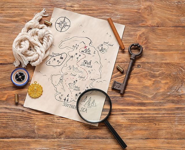 Carte au trésor, loupe, boussole, clé ancienne et cordage sur une table en bois