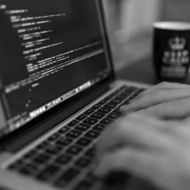 Programmeur tapant du code sur son ordinateur, ambiance tech dans Hack The Room chez A Maze In