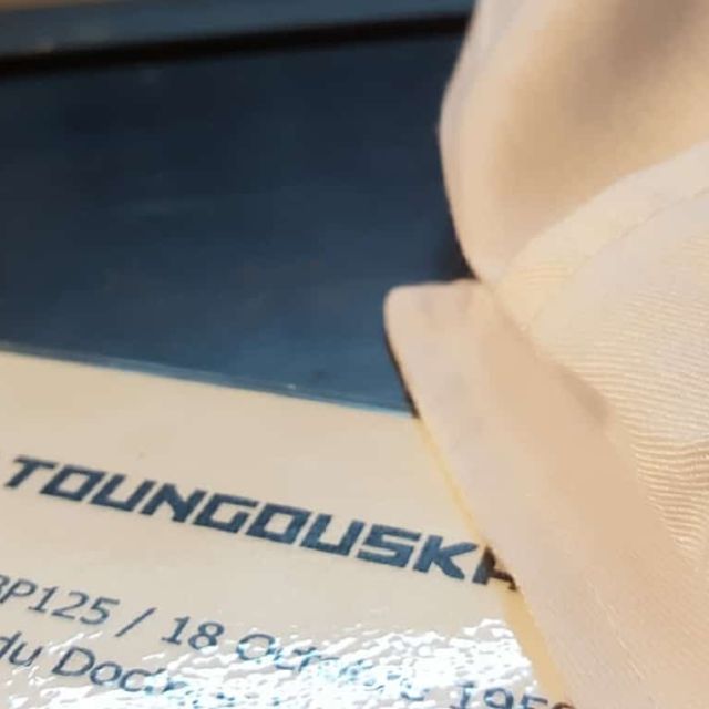 Badge à étoile rouge posé près d'une fiche d'expérience Projet Toungouska, salle Le labo en feu à Toulouse