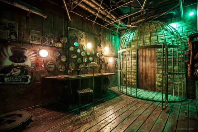 Décor steampunk avec cage métallique, établi, cadrans et luminaires suspendus chez Mastermind à Bern