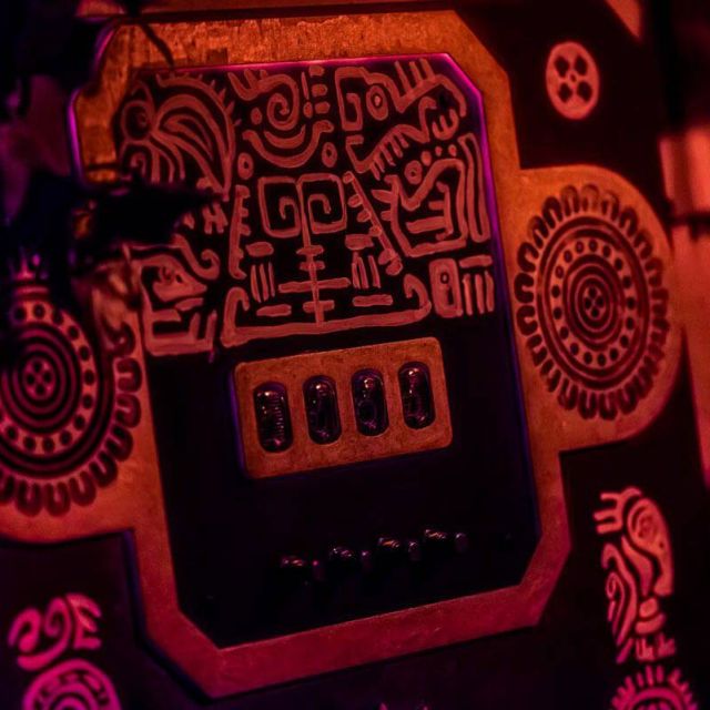 Panneau de contrôle aux motifs mayas en relief sous éclairage rouge et violet