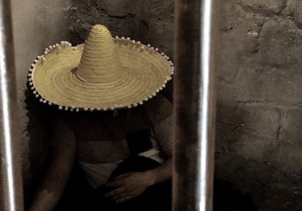 Personne au chapeau de paille assise derrière des barreaux, salle El Cartel de San Pedro, TooLate Tours