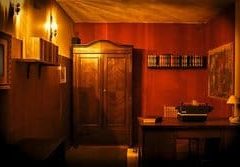Intérieur rougeâtre aux murs couleur ocre, mobilier ancien et objets vintages disposés dans une pièce close chez Questory à Berlin