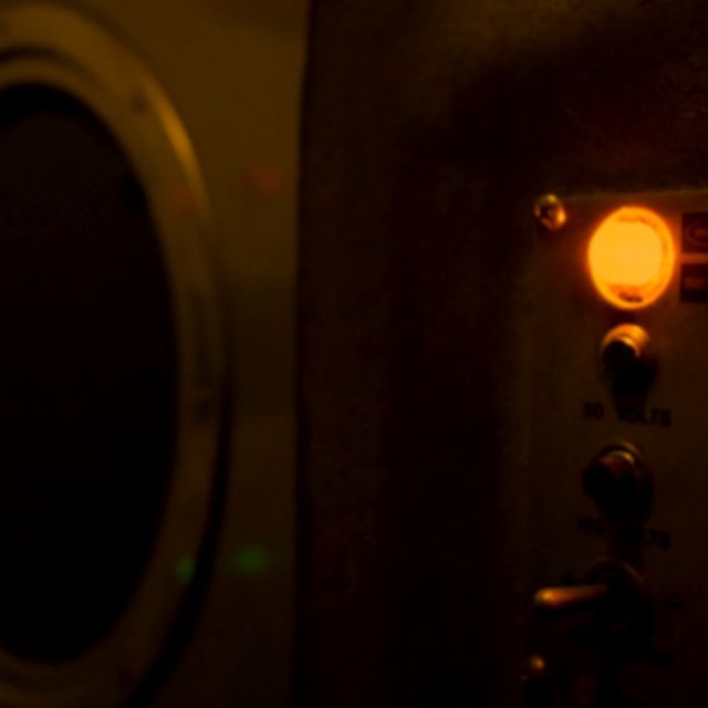 Hublot rond et deux voyants orange sur une cloison brune, salle Tchernobyl chez Wood Escape à Locquignol