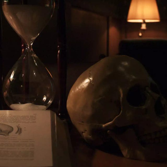 Crâne, sablier et livre ancien dans une ambiance sombre chez Crack the egg à Paris