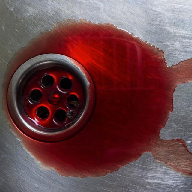 Bonde d'évier rouge de sang sur une surface métallique, enseigne You have sixty minutes à Paris