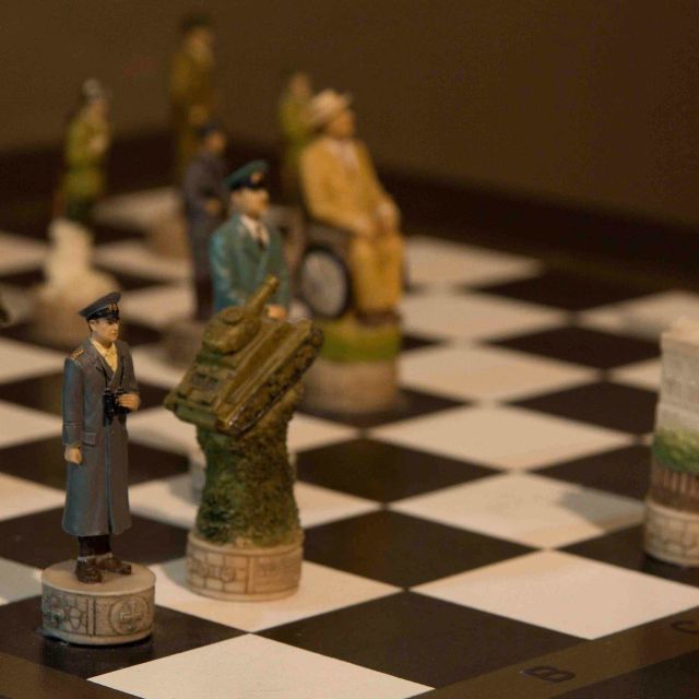 Échiquier avec pièces stylisées représentant soldats et bâtiments historiques, thème de stratégie militaire