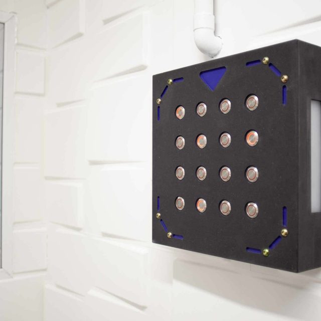 Panneau de contrôle noir aux seize boutons lumineux dans salle LIVE Corp. Escape Game Montpellier