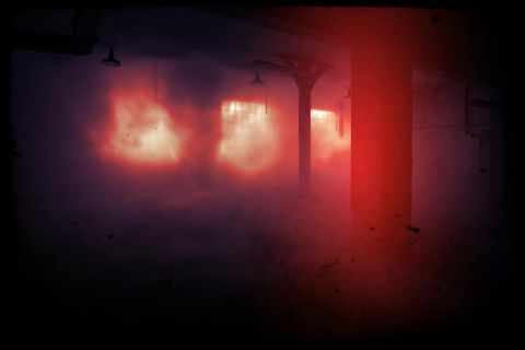 Lueurs rouges dans une usine sombre enfumée, salle Panic Factory chez Escape Quest à Angoulême