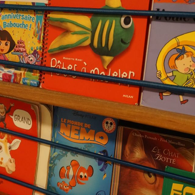Étagère colorée de livres pour enfants dont Le Monde de Nemo, dans L'école de M. Berthelot