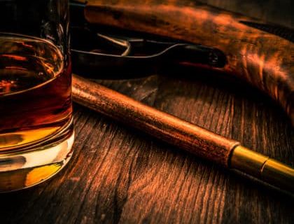 Verre de whisky et revolver sur bois sombre, ambiance années 1920 à Nice chez Aventure Live! Escape Game
