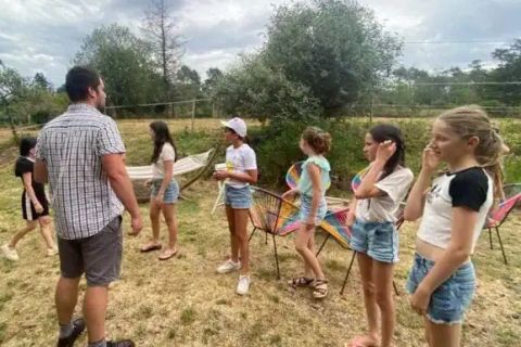 Groupe d'enfants et un adulte debout dans un pré, jeu en plein air, salle L'hôtel maudit de Gaël, En Quête de Brocéliande