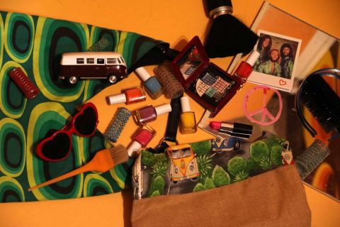 Sac à main renversé : maquillage, lunettes cœur, mini van et photos sur un tissu vert, salle Le salon de Betty, Nant'escape