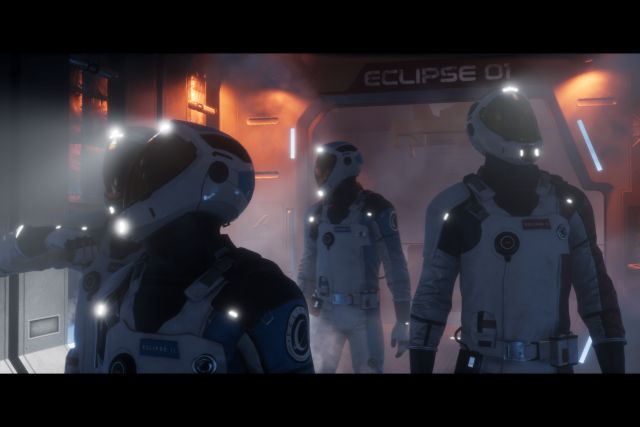 Trois astronautes en combinaison sombre dans un couloir de vaisseau orangé, salle Eclipse chez Virtual Adventure à Lieusaint