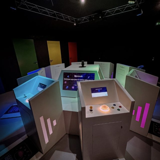 Salle futuriste aux éléments luminescents colorés et panneaux interactifs chez Break Out – Sévrier