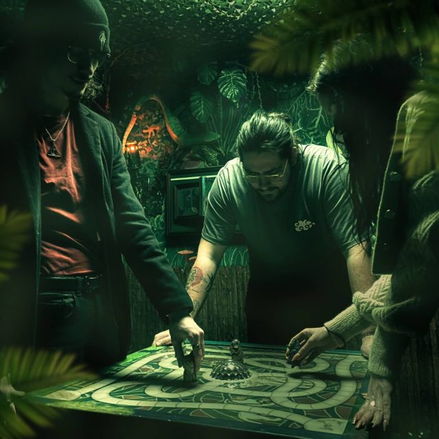 Joueurs penchés sur un plateau de jeu à labyrinthe entouré de feuilles, salle Zoomanji chez Freeing à Saint-Maximin