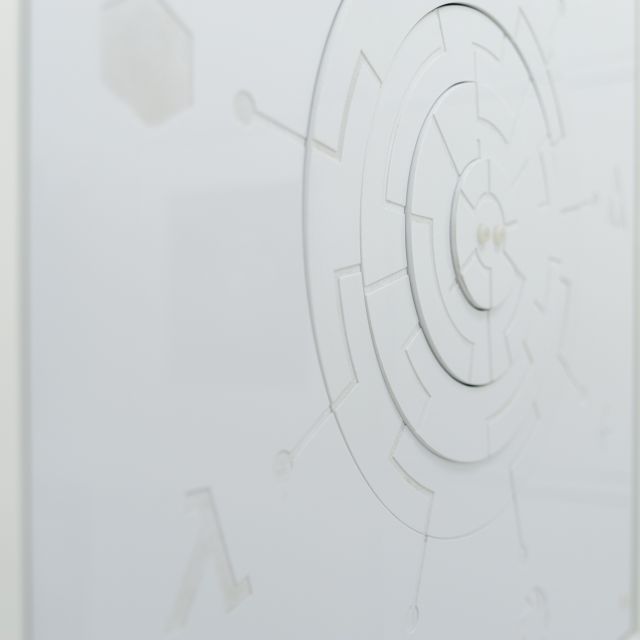 Mur blanc orné d'un motif de labyrinthe circulaire en relief, salle Le cube à Lille