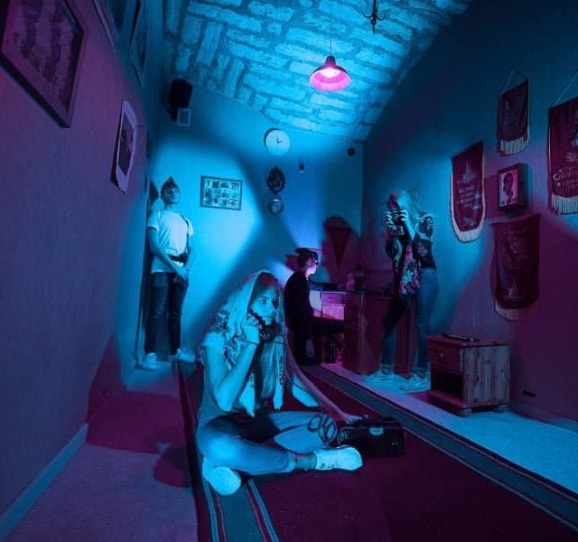 Décor d'une salle KGB avec mannequins, drapeaux soviétiques et éclairage bleu-rouge chez Skryptic Escape Game