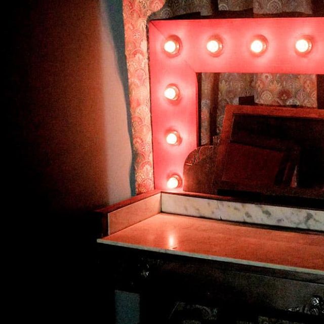 Miroir de loge avec ampoules rouges dans la salle Escape Circus