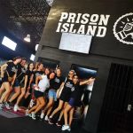 Groupe de joueurs devant l'entrée de Prison Island à Aubière, décor carcéral noir
