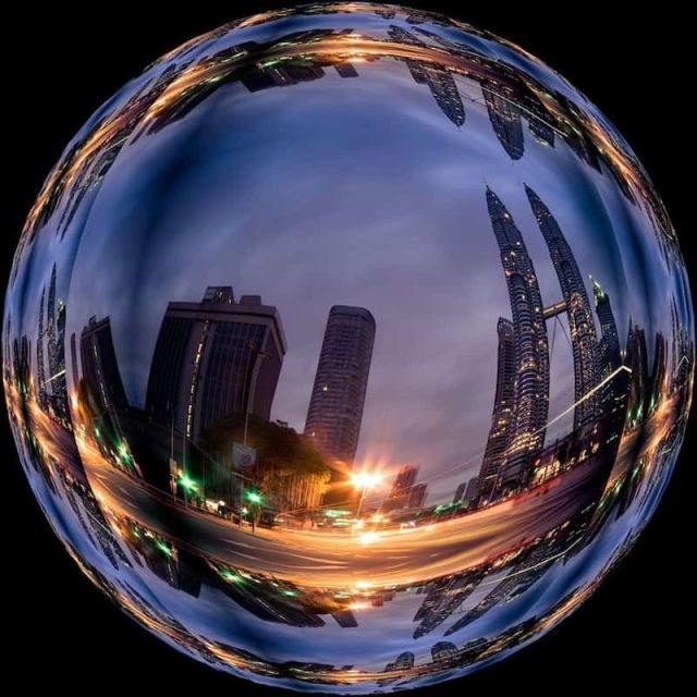 Sphère de verre reflétant des gratte-ciel au crépuscule, galerie de la salle Atteindre Utopia chez Mindtrap à Serris